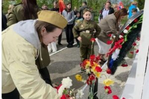 Жители возлагают цветы к памятнику в День Победы